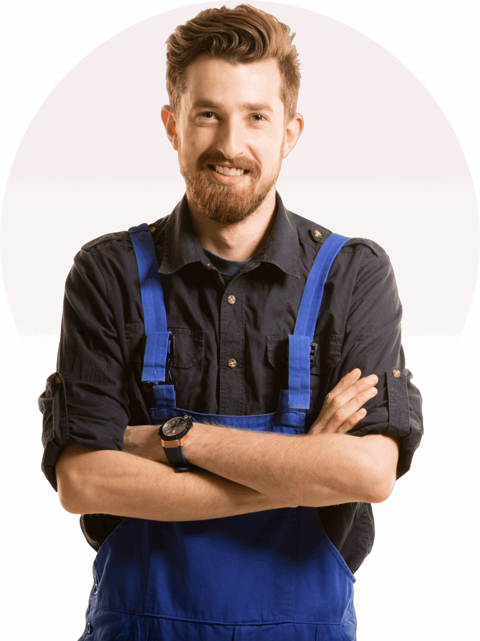 A man with a beard, wearing a dark shirt and blue overalls, stands with arms crossed and smiles in front of a red background with a darker red circle.